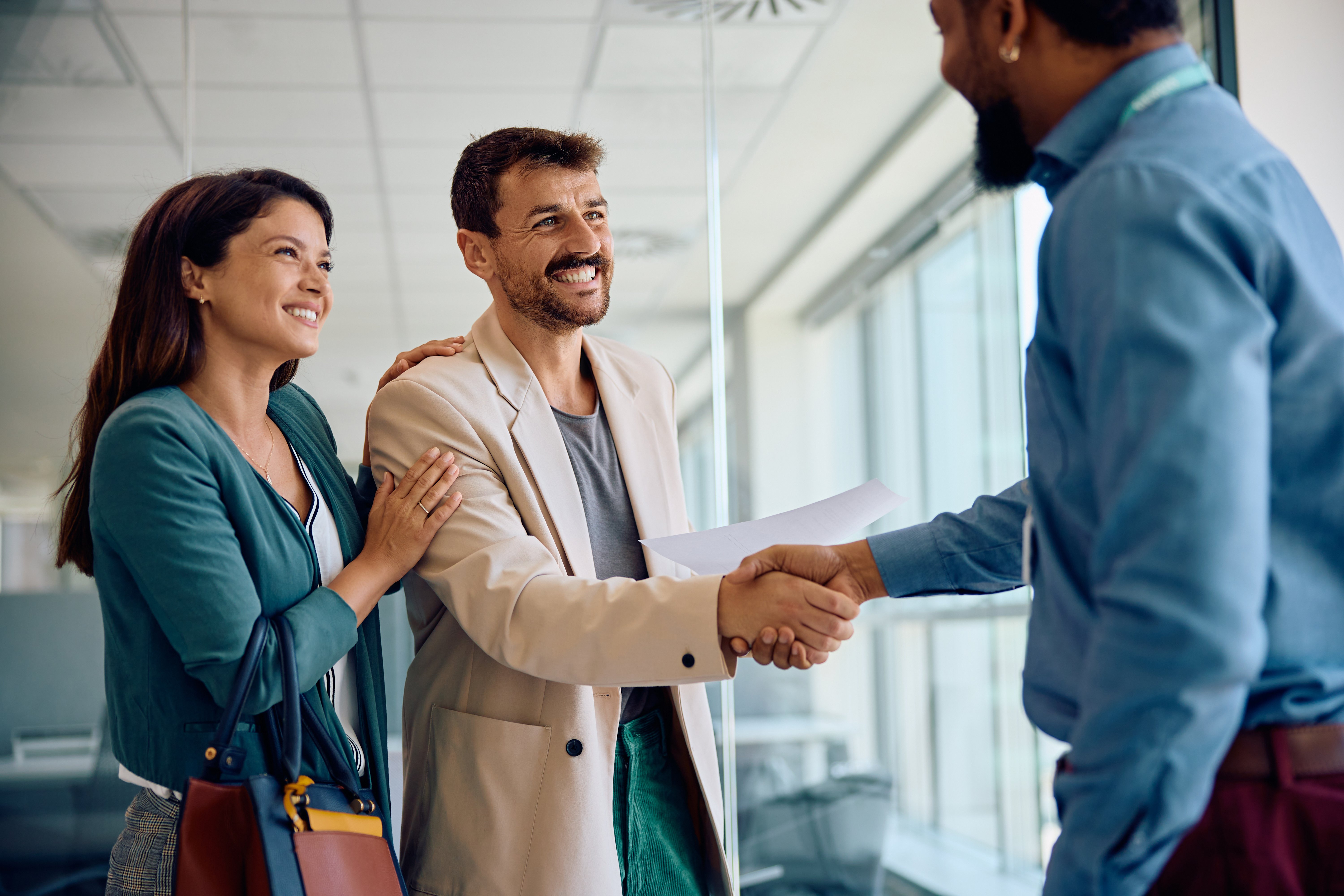 happy-couple-handshaking-with-their-financial-advi-2024-01-12-16-47-59-utc